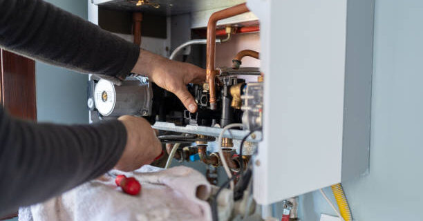Technician Repairing Natural Gas Combi Boiler At Home